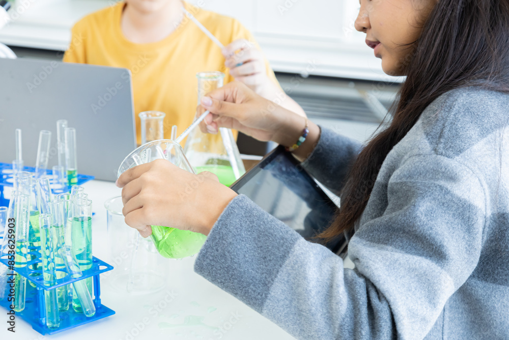 Lab Testing Supervision Asian students in science class performing chemial experiments with ...
