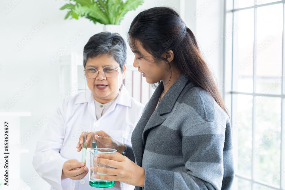 Senior teacher guiding student girl handle chemical solutions in laboratory. Young woman holding beaker and test tube experiments. Educational environment promoting practical learning, back-to-school Senior teacher guiding student girl handle chemical solutions in laboratory. Young woman holding beaker and test tube experiments. Educational environment promoting practical learning, back-to-school