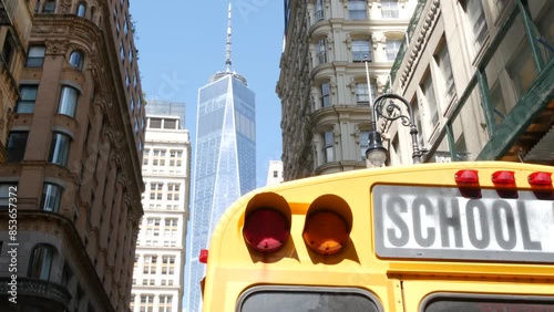Yellow School Bus. Schoolbus back view on Fulton street, New York City Manhattan Downtown. Children education and transportation, USA. American school shuttle, World Trade Center tower, United States.