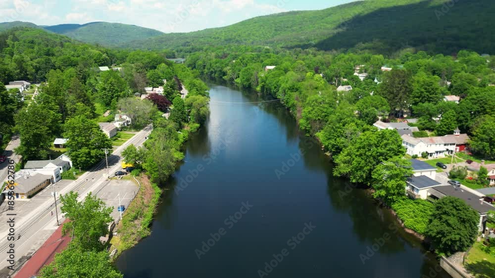 Scenic overview of calm waters of Deerfield River in between lush greenery and quaint town in Massachusetts -aerial dolly Scenic overview of calm waters of Deerfield River in between lush greenery and quaint town in Massachusetts -aerial dolly
