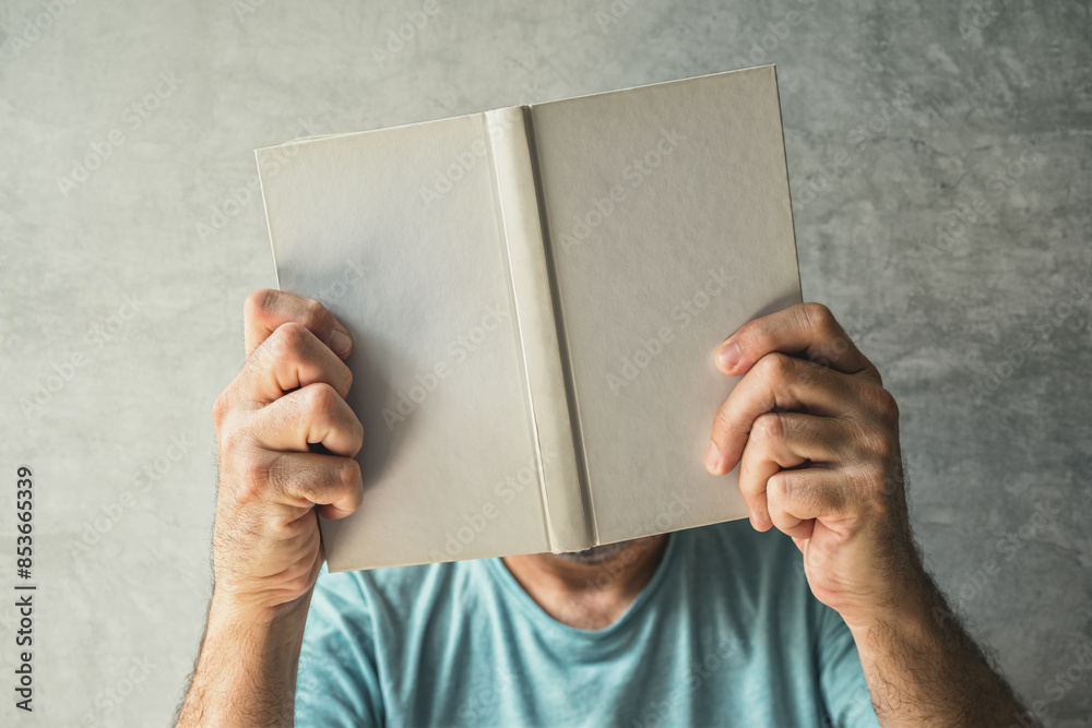 Ταπετσαρία Man reading book, his face is obscured by the hardcover poetry booklet