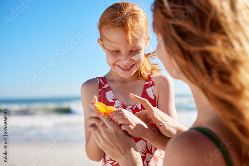 Lovely mother applying sunscreen on cute little girl on cheeks