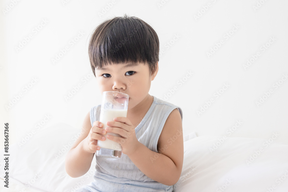 A Chinese little girl drinking milk in bedroom A Chinese little girl drinking milk in bedroom