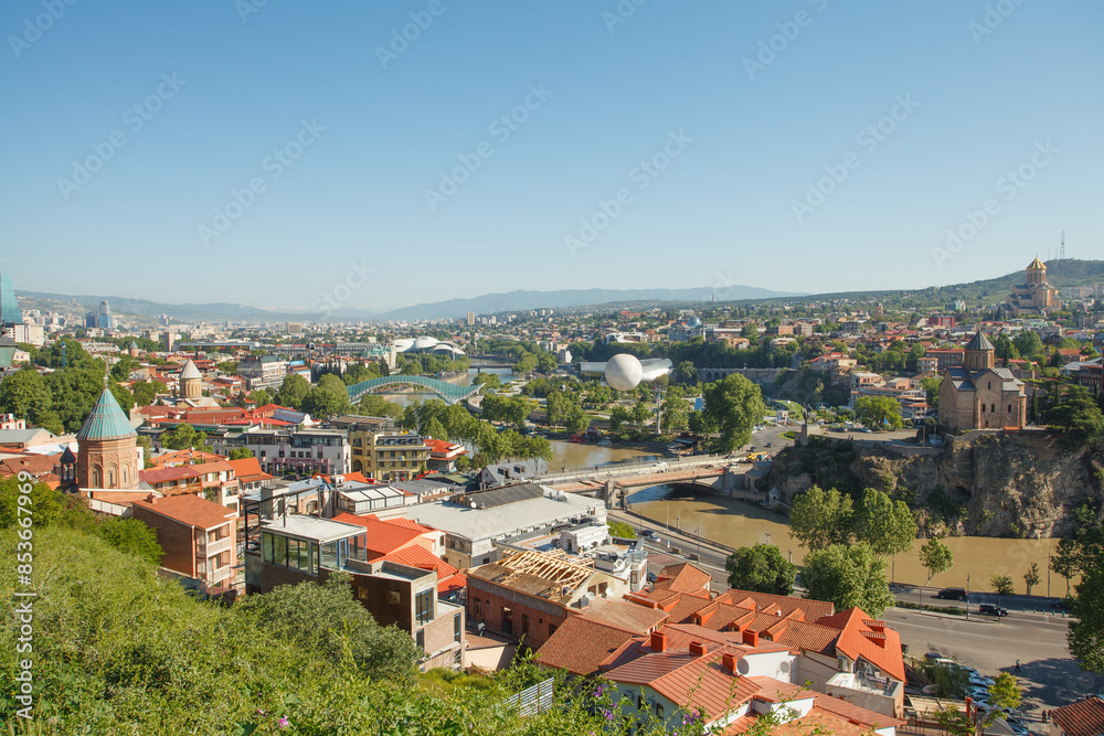 Landscape of old town Tbilisi and river on the background of blue sky and green mountains Landscape of old town Tbilisi and river on the background of blue sky and green mountains