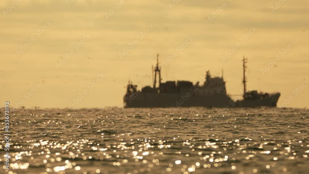 Abstract sea ocean sunset nature background with seagulls and fishing boat trawler catches fish while sailing on sea at horizon in distance sail to catch school of fish on calm sea surface in summer. Abstract sea ocean sunset nature background with seagulls and fishing boat trawler catches fish while sailing on sea at horizon in distance sail to catch school of fish on calm sea surface in summer.