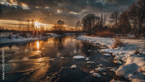 A serene winter scene with a river and snow-covered trees at sunset.