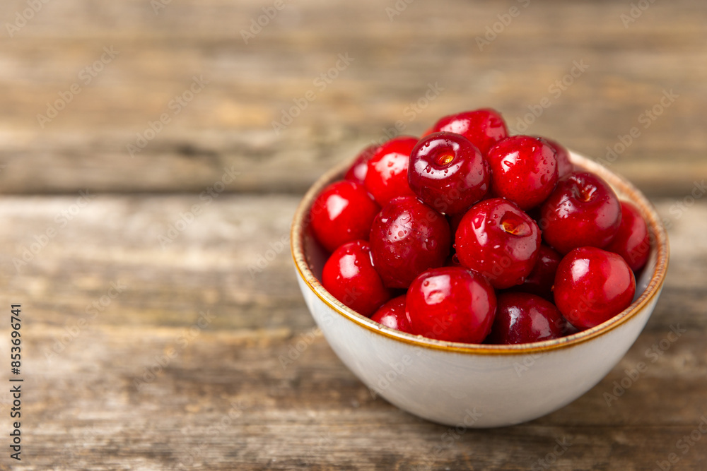 Cherries. Fresh ripe cherries with leaves on a textured wooden background. Fresh sweet organic cherry pile. Berries and fruits. Vegan. Healthy eating. Place for text. Copy space Cherries. Fresh ripe cherries with leaves on a textured wooden background. Fresh sweet organic cherry pile. Berries and fruits. Vegan. Healthy eating. Place for text. Copy space