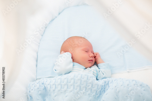 Newborn baby boy in white bassinet