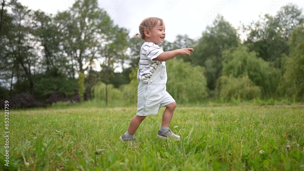 A baby and toddler are running around in a park. Sky joy rain concept. A child runs on the grass in a park. A toddler running on the grass with a baby. happy family lifestyle concept. A baby and toddler are running around in a park. Sky joy rain concept. A child runs on the grass in a park. A toddler running on the grass with a baby. happy family lifestyle concept.
