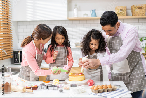 Portrait of enjoy happy love asian family father and mother with little asian girl daughter child play and having fun cooking food together with baking cookie and cake ingredient in kitchen