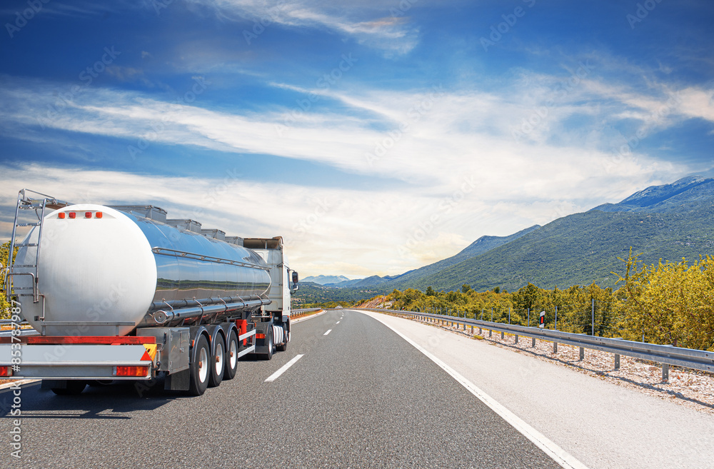 Fuel truck on a picturesque road. A silver tank truck transports fuel.