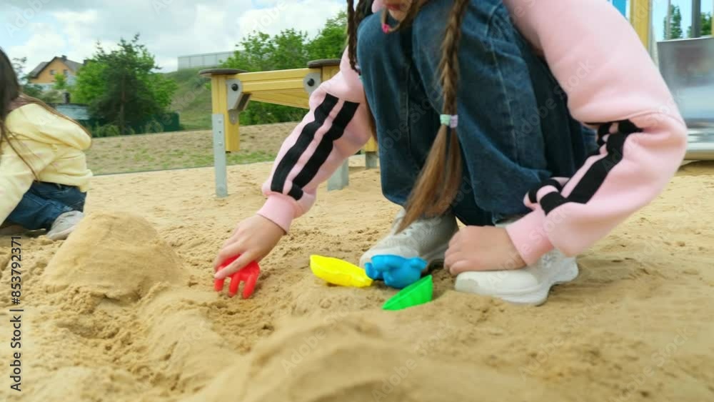 Close-up of little girl playing with molds in sand on the beach, slow motion. Happy childhood concept Close-up of little girl playing with molds in sand on the beach, slow motion. Happy childhood concept