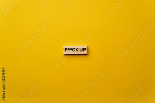 Fotografija a yellow warm background without shadows wooden cubes with black letters laid ou
