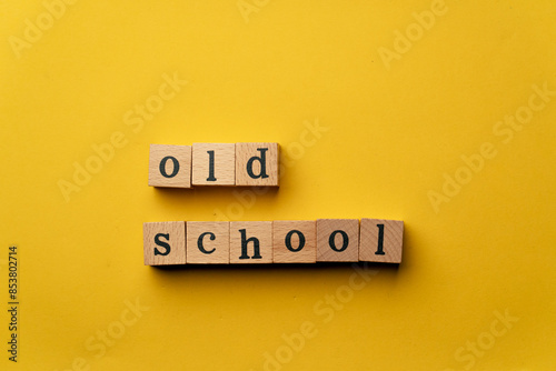 a yellow warm background without shadows wooden cubes with black letters laid out word old school