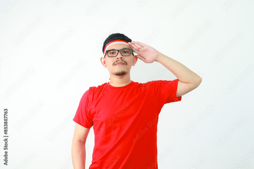 Young Asian man standing confidently giving salute and respectful gestures isolated over white background. Celebrate Indonesia independence day on 17 August Young Asian man standing confidently giving salute and respectful gestures isolated over white background. Celebrate Indonesia independence day on 17 August