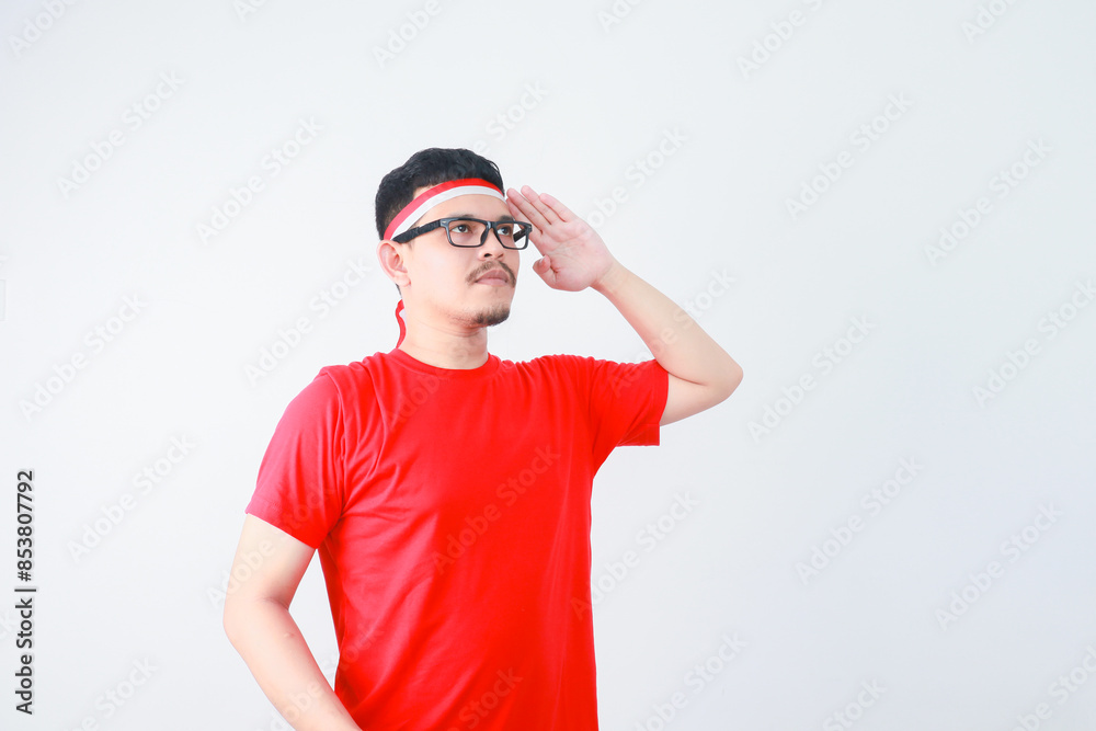 Young Asian man standing confidently giving salute and respectful gestures isolated over white background. Celebrate Indonesia independence day on 17 August Young Asian man standing confidently giving salute and respectful gestures isolated over white background. Celebrate Indonesia independence day on 17 August