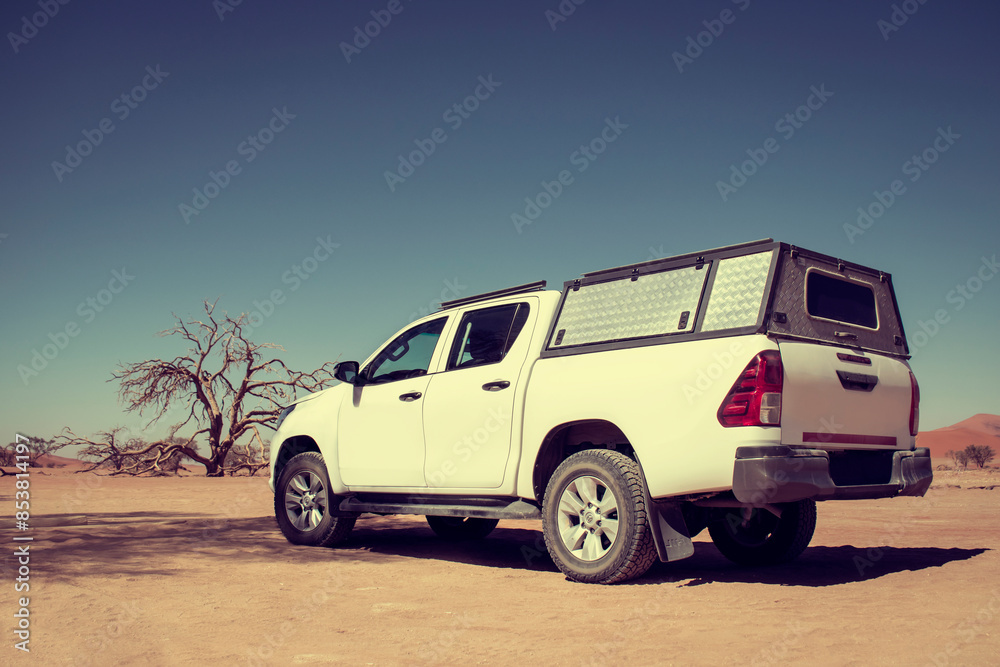 Fototapeta premium White off road car in the middle of desert on a hot sunny day