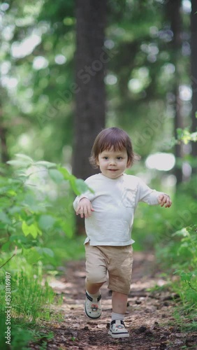 The toddler is running and playing in the forest, enjoying a carefree childhood. The child is running around in the green grass, living a summer lifestyle.