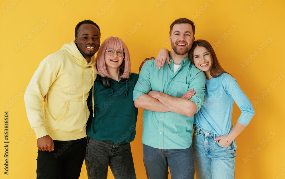 Front view. Group of friends are in the studio against background Front view. Group of friends are in the studio against background
