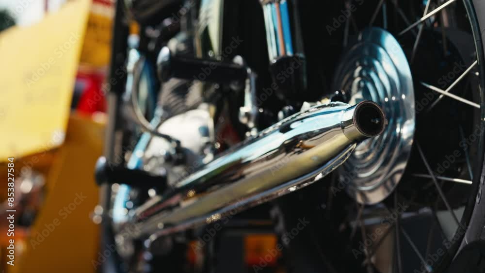 Slow motion shows details of a classic motorcycles shiny exhaust pipe, highlighting its mechanical design Slow motion shows details of a classic motorcycles shiny exhaust pipe, highlighting its mechanical design