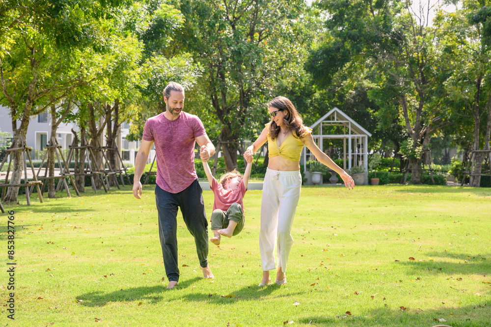 Fototapeta premium Happy family walking and playing together in garden. little children with parents are free and active people in nature. Feeling of fun and enjoyment concept. Family day.