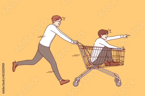 Business man rides partner on carts from supermarket, for concept of managing retail company or store. Two supermarket managers are fooling around using shopping cart for other purposes