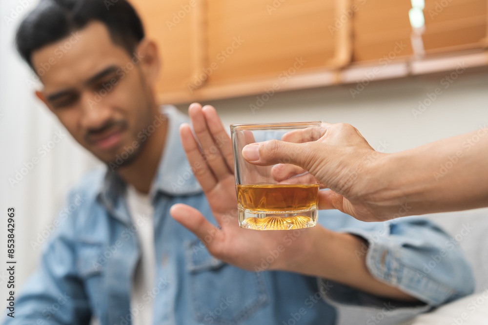 Alcoholism, depressed asian young man refuse, push out alcoholic beverage glass, drink whiskey, sitting alone at night. Treatment of alcohol addiction, having suffer abuse problem alcoholism concept. Alcoholism, depressed asian young man refuse, push out alcoholic beverage glass, drink whiskey, sitting alone at night. Treatment of alcohol addiction, having suffer abuse problem alcoholism concept.