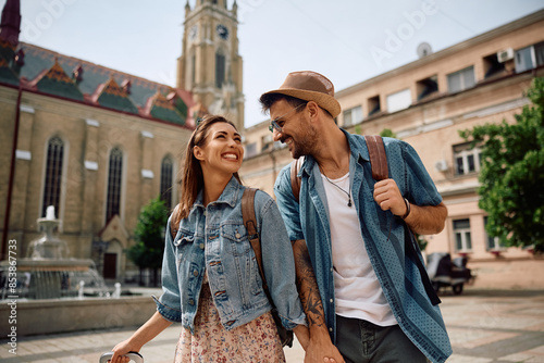 Young happy couple of travelers on town square.