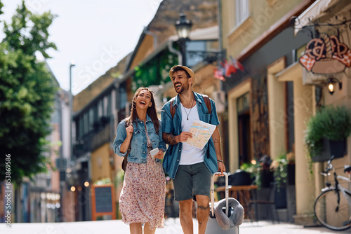 Cheerful couple of tourists walking in  city while traveling together. photo