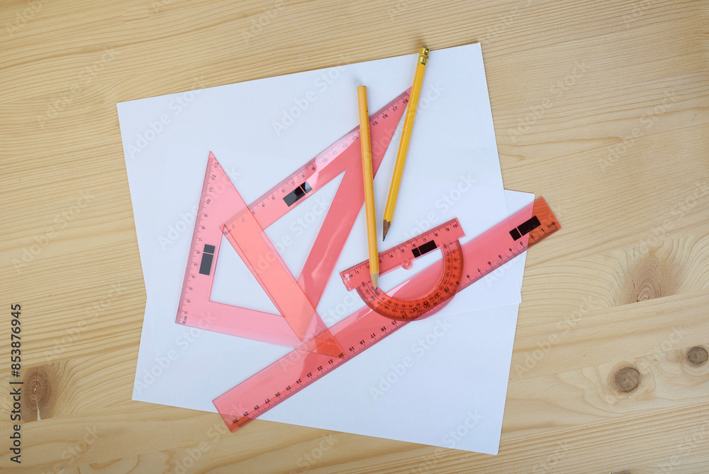 Fototapeta premium Drawing set made of rulers, traportir with pencils on sheets of paper.
