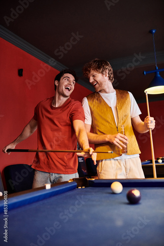 Friends play billiards in a casual setting, laughing and enjoying the game.