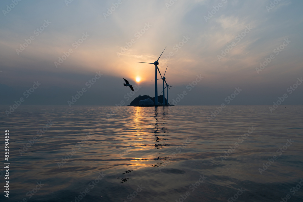 View of the wind turbines and flying seagulls during sunset on the sea View of the wind turbines and flying seagulls during sunset on the sea