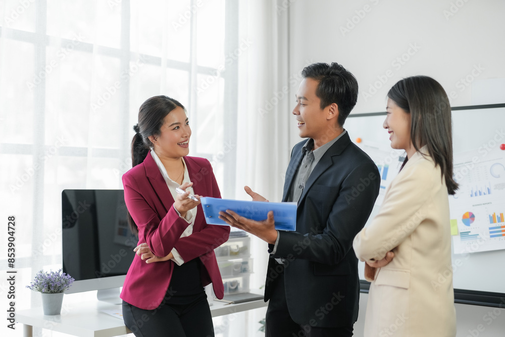 Business team discussing project with charts in modern office. Collaborative, productive meeting with executives sharing ideas and plans.