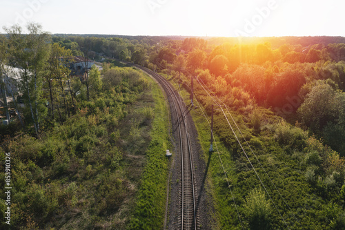 Railway through summer forest. Aerial view.  Sunset time