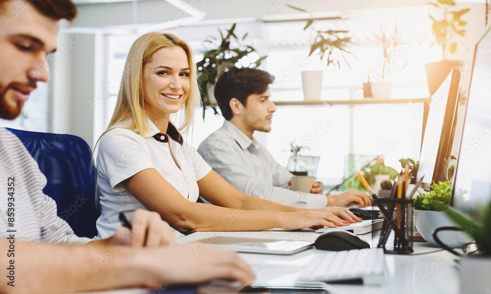 A group of diverse individuals are sitting at a desk, concentrating intently as they work on their computers. Each person is focused on their screen, typing, clicking, and scrolling A group of diverse individuals are sitting at a desk, concentrating intently as they work on their computers. Each person is focused on their screen, typing, clicking, and scrolling