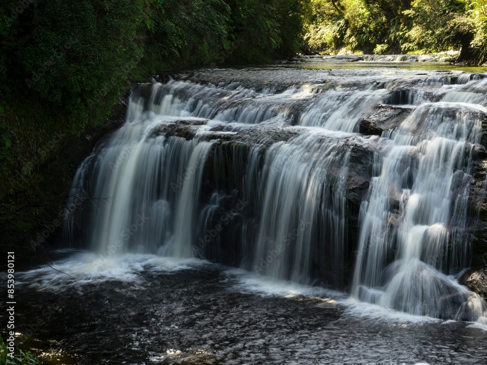 Fototapeta premium Silky white long exposure shot of idyllic Coal Creek Falls river waterfall flowing in Runanga Greymouth New Zealand