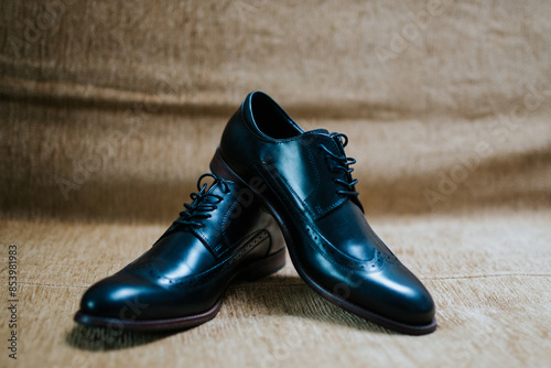 A pair of elegant black dress shoes is displayed, showcasing their polished finish and detailed craftsmanship.