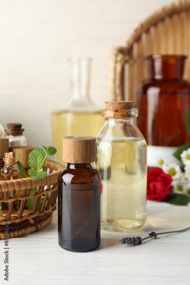 Aromatherapy. Different essential oils and green leaves on white wooden table Aromatherapy. Different essential oils and green leaves on white wooden table