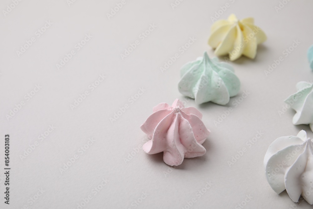 Delicious meringue cookies on light background, closeup. Space for text Delicious meringue cookies on light background, closeup. Space for text