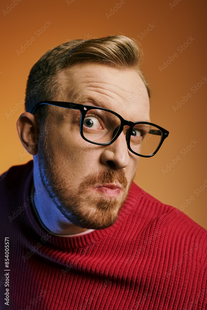 A stylish man in red sweater and eyeglasses striking a pose. A stylish man in red sweater and eyeglasses striking a pose.