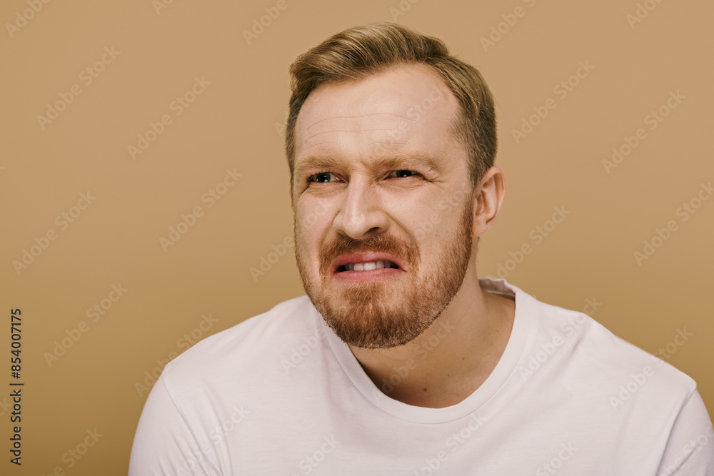 A stylish man with a beard in a white shirt striking a pose. A stylish man with a beard in a white shirt striking a pose.