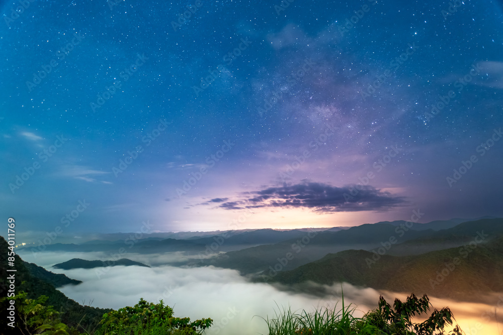 The starry sky, Milky Way and sea of clouds at night combine into a painting. View of the mountains surrounding Emerald Reservoir. Xindian District, Taiwan. The starry sky, Milky Way and sea of clouds at night combine into a painting. View of the mountains surrounding Emerald Reservoir. Xindian District, Taiwan.