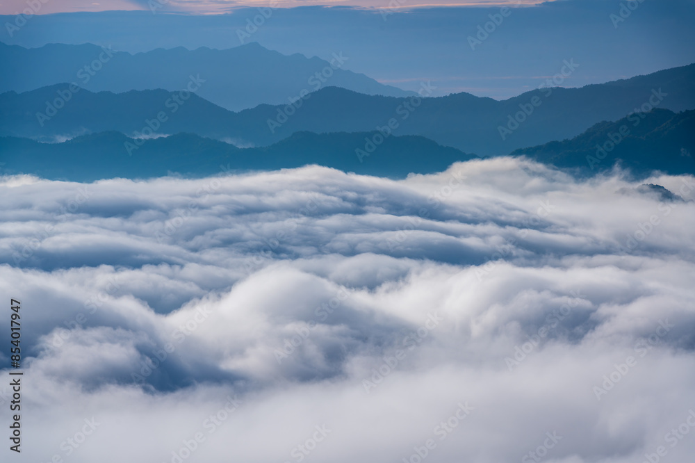 The sunlight makes the sea of clouds change unpredictably, like stormy waves. View of the mountains surrounding Emerald Reservoir. Xindian District, Taiwan. The sunlight makes the sea of clouds change unpredictably, like stormy waves. View of the mountains surrounding Emerald Reservoir. Xindian District, Taiwan.
