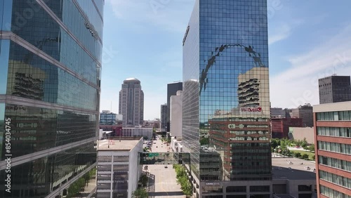 Vertical drone footage of downtown Saint Louis, Missouri with buildings in the arch showing in window reflections on a bright and sunny summer day.