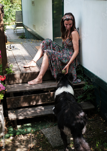 Obraz na płótnie Foto scattata ad una ragazza in posa con il suo cucciolo di border collie in un bungalow situato a Marina di Campo nell'isola d'Elba. w salonie
