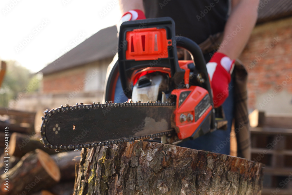 Man sawing wooden log outdoors, closeup view Man sawing wooden log outdoors, closeup view
