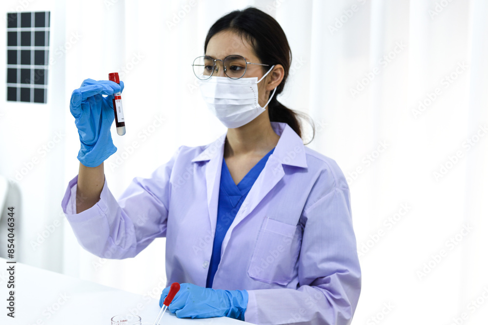 Scientist holding Coronavirus covid-19 infected blood sample tube DNA testing of the blood in the laboratory with blood sample collection tubes and syringe Coronavirus Covid-19 vaccine research. Scientist holding Coronavirus covid-19 infected blood sample tube DNA testing of the blood in the laboratory with blood sample collection tubes and syringe Coronavirus Covid-19 vaccine research.