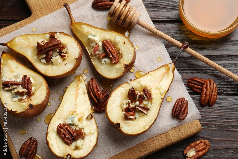 Tasty baked pears with nuts, blue cheese, thyme and honey on wooden table, flat lay Tasty baked pears with nuts, blue cheese, thyme and honey on wooden table, flat lay