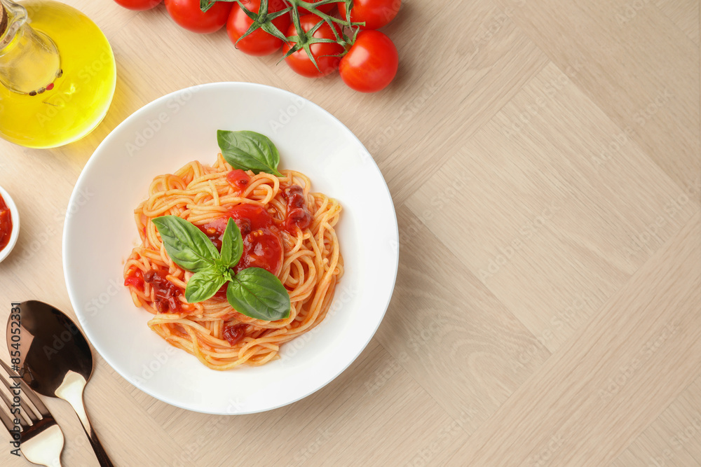Delicious pasta with tomato sauce and basil in bowl on wooden table, flat lay. Space for text Delicious pasta with tomato sauce and basil in bowl on wooden table, flat lay. Space for text