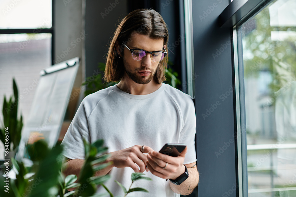 Fototapeta premium A caucasian businessman in a white shirt focused on his phone.